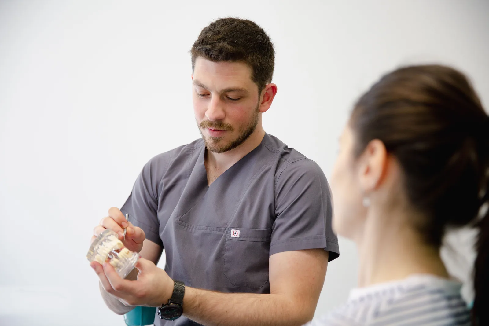 Dentist showing an implant model during a consultation, referred to in the Single Tooth Implant section for Toronto