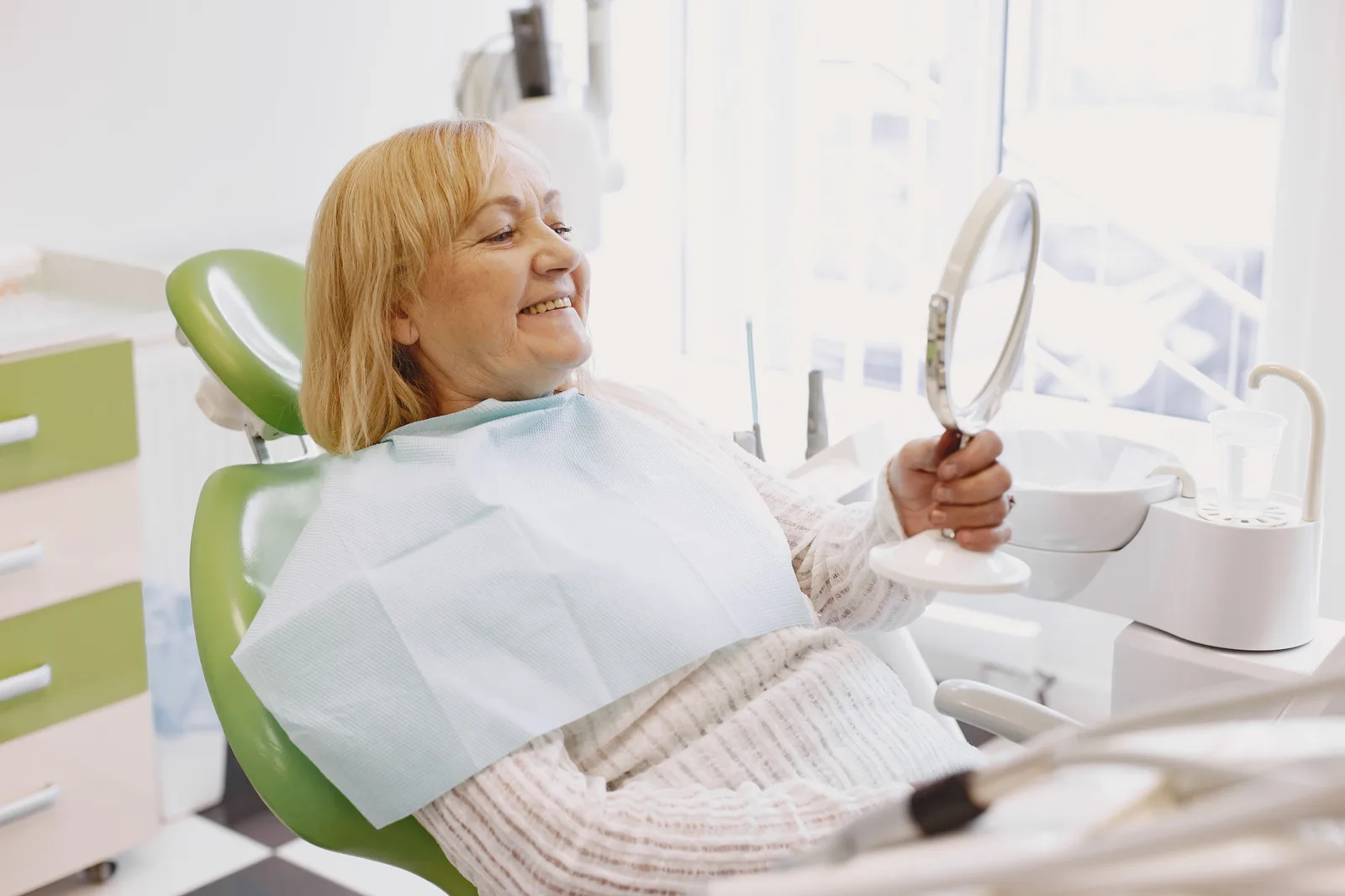 Patient reviewing a new smile in the mirror, shown while covering Full Mouth Cost in Toronto