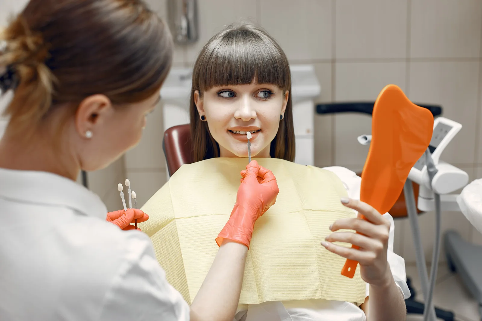 Patient checking crown shade in a hand mirror, alongside the Sinus Lift Surgery explanation in Toronto